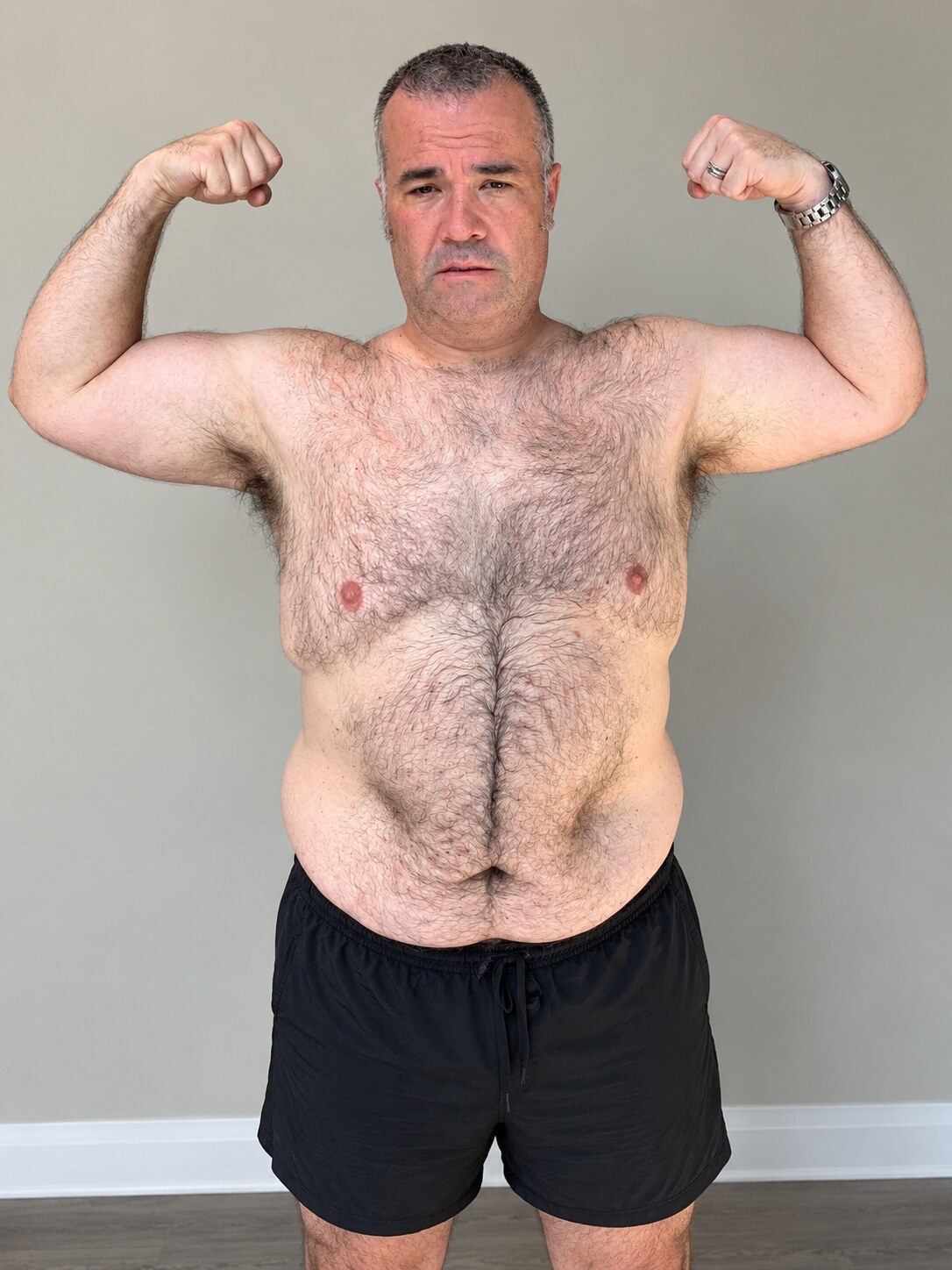 Terry before his transformation, standing in black shorts and flexing