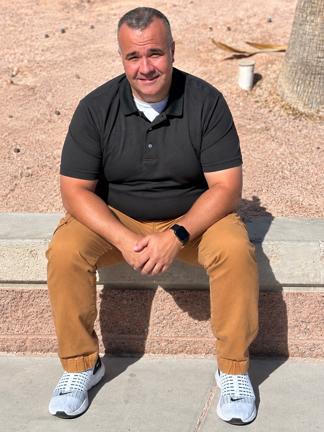 Terry before his transformation, seated outside in a black polo